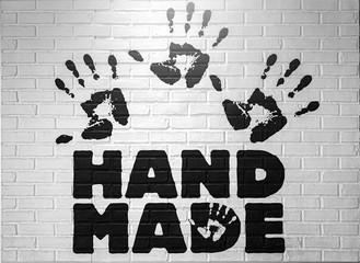 Hand marks or handprint by a slap and word hand made on a white brick wall.  abstract dirty background.