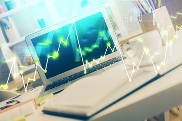 Stock market chart hologram drawn on personal computer background. Double exposure. Concept of investment.