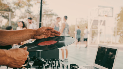 Outdoor music party. Dj playing on vinyl. Dj's hands and turntable close up