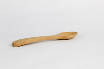 Brown wood spoon at the white background with the lighting