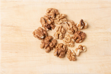 Peeled walnuts on a wooden cutting board on a white background