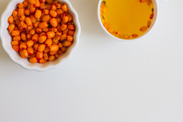 Vitamin useful sea buckthorn tea in a glass teapot with fresh sea buckthorn berries, orange, cinnamon sticks and honey. The concept of rest, relaxation. top view with a copy of the space