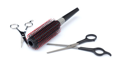 Two professional hairdresser scissors and comb on white background.