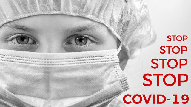 The child in a medical mask and safety cap on white background with inscriptions STOP COVID-19. Coronavirus protection. Black and white photo. Closeup