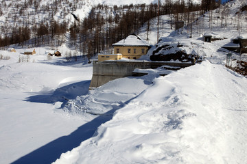 Fototapeta na wymiar Devero Park ( Verbano-Cusio-Ossola ), Italy - January 15, 2017: The Codelago dam in Alpe Devero Park, Ossola Valley, VCO, Piedmont, Italy
