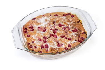 Cherry clafoutis in glass casserole pan on a white background
