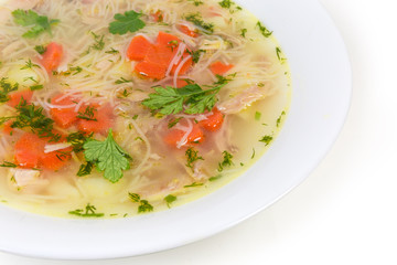 Chicken soup with thin short vermicelli in dish close-up