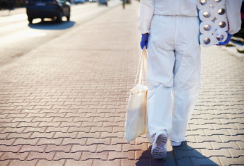 Person in protective suit walking back from shopping