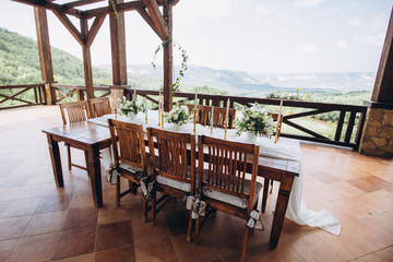 The wedding table decorated with fresh flowers is newlywed with a view of the mountains. 