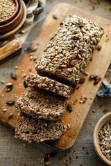Gluten-free homemade buckwheat bread with the addition of various seeds cut into slices on a wooden...