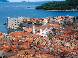 Top view of the old town of Dubrovnik and the Fort on a Sunny clear day, behind the city is a beautiful blue sea, green island and white yachts