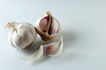 whole garlic bulb and an open one with single clove