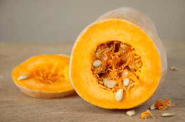 Raw ripe pumpkin sliced in rings lies on a wooden table. Product for preparing a healthy vegetarian diet. The basics of a healthy diet.