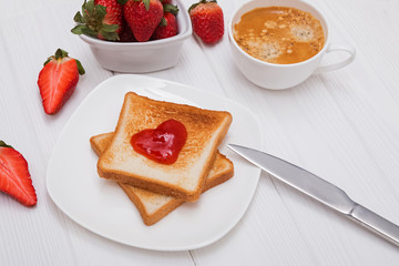 Fresh toasts with strawberry jam in heart shape, coffee and strawberries