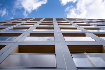 Exterior of new apartment buildings on a blue cloudy sky background. No people. Real estate business concept.