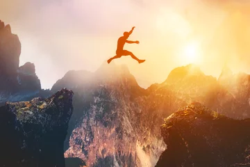 Fotobehang Man jumping between rocks. Overcome a problem for a better future © Photocreo Bednarek