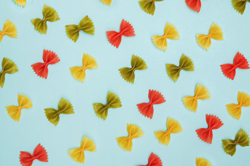 Dry colorful Italian pasta farfalle or bows on blue backgroun