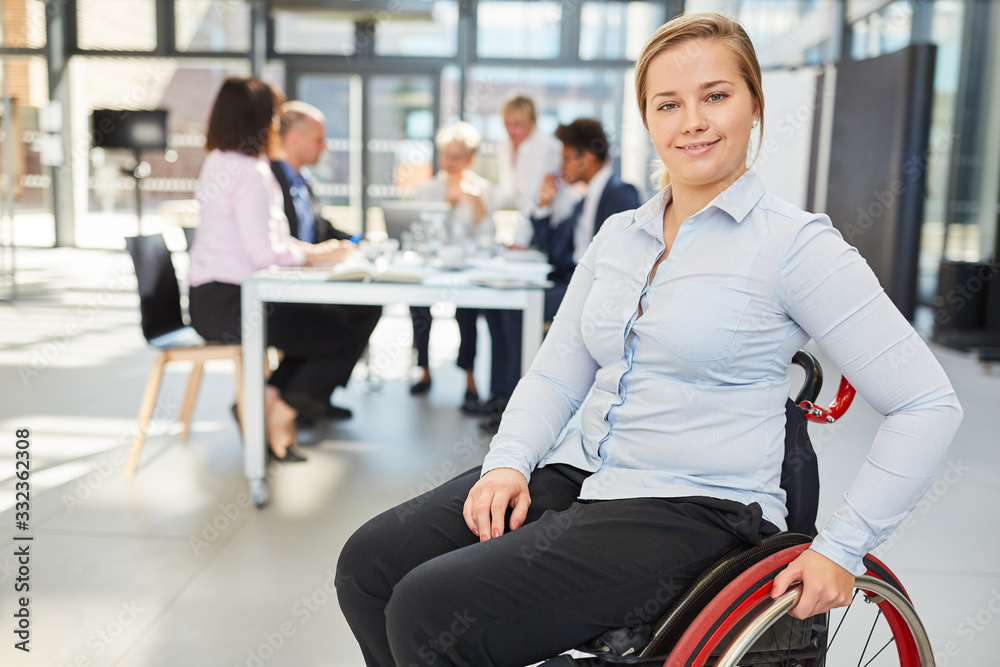 Wall mural woman in a wheelchair in the office as a business inclusion concept