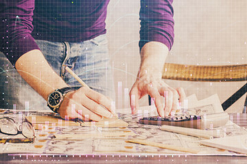 Multi exposure of man standing and planing investment with stock market forex chart.