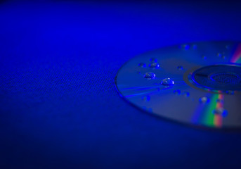  CD disk with droplets of water in blue light close-up