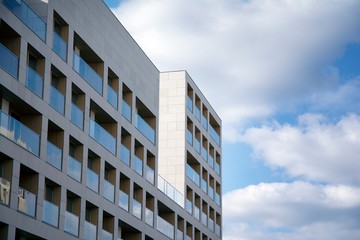 Exterior of new apartment buildings on a blue cloudy sky background. No people. Real estate business concept.