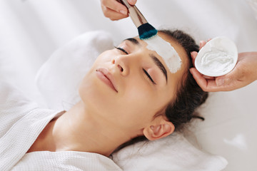 Fototapeta na wymiar Close-up image of young woman getting moisturizing mask in beauty salon