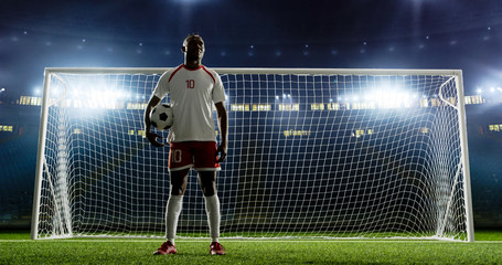 Soccer player is standing in front of the goal on the empty soccer stadium. No spectators on the tribunes. Stadium is made in 3D.