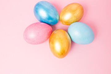Multi-colored Easter eggs on a pink isolated background. Easter is a bright holiday.