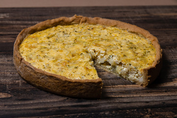 Kish with caramelized onions, dill and cream cheese on a Wooden Table