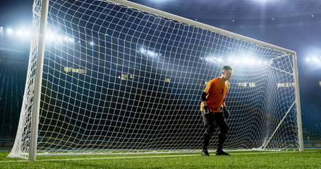 Fototapeta na wymiar Goalkeeper is trying to save from a goal on an empty soccer stadium. No spectators on the tribunes. Stadium is made in 3d.