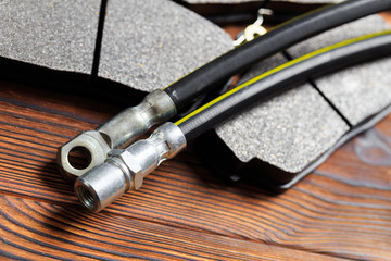 brake parts on wooden background  brake pads, disc, brake hose, guides, cylinders- Image