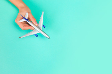  Beautiful young woman's hands holding plane    on pastel  background .