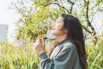 Asian girl facing the sun is taking off the mask 