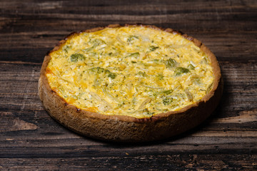 Appetizing kish with broccoli and cheese on on a Wooden Table