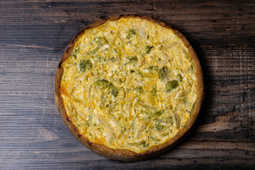 Appetizing kish with broccoli and cheese on on a Wooden Table