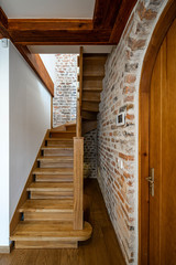 Modern contemporary loft interior of private house. Wooden staircase. Brick wall.