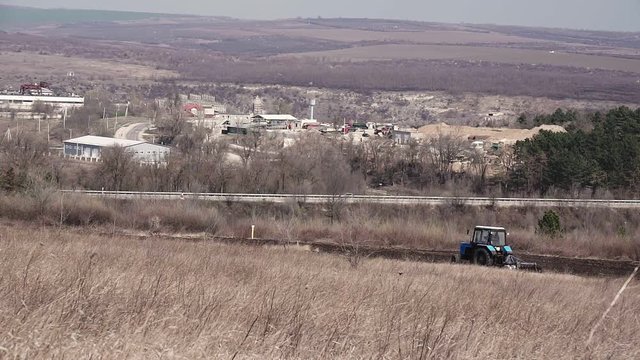 Tractor plows a field in spring