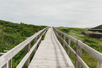 Fototapeta na wymiar Wood boardwalk at Inverness Beach on the west coast of Cape Breton Island, Nova Scotia, Canada