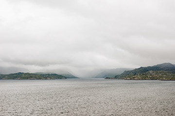 Aview over the scottish coastline from across the ocean with cloudy sky