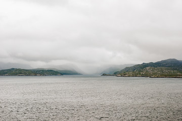 Aview over the scottish coastline from across the ocean with cloudy sky