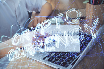 Cryptocurrency hologram, bitcoin, ico theme over hands taking notes background. Concept of...