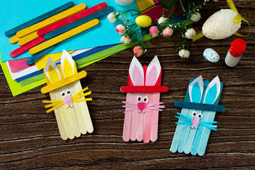 Easter bunny toy gift stics puppets on wooden table. Handmade. Project of children's creativity,...