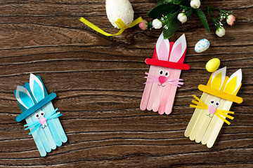 Easter bunny toy gift stics puppets on wooden table. Copy space. Handmade. Project of children's...
