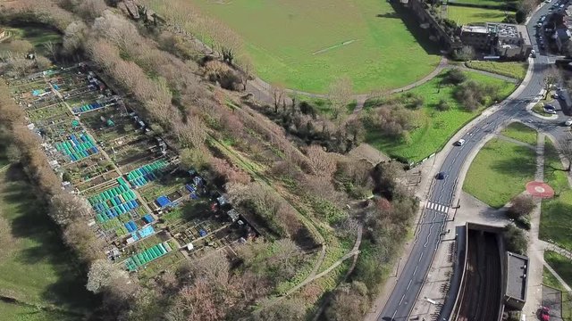 Aerial drone view of millwall park in mudchute london in a sunny winter day during daytime as the cars passing by on the road nearby.