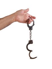 Male hand holding metal hand cuffs isolated on white background . - 332369399
