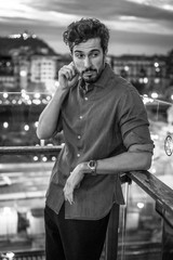 Street style, a young Caucasian man with the city in the background