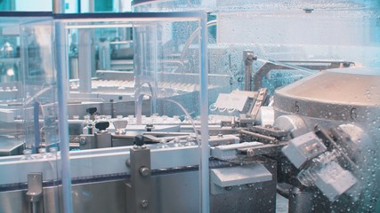 Glass bottles in production in the tray of an automatic liquid dispenser, a line for filling medicines against bacteria and viruses, antibiotics and vaccines.