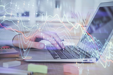Double exposure of stock market graph with man working on laptop on background. Concept of financial analysis.