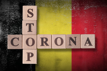 Obraz premium Flag of Belgium with wooden cubes spelling STOP CORONA on it. 2019 - 2020 Novel Coronavirus (2019-nCoV) concept art, for an outbreak occurs in Belgium.