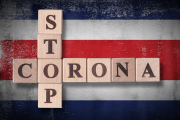 Obraz premium Flag of Costa Rica with wooden cubes spelling STOP CORONA on it. 2019 - 2020 Novel Coronavirus (2019-nCoV) concept art, for an outbreak occurs in Costa Rica.